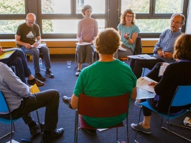 Une salle de réunion avec des personnes assises en cercle sur des chaises