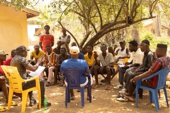 In einem Dorf im Distrikt von Port Loko diskutieren Dorfbewohner über das umstrittene CO2-Kompensationsprojekt.