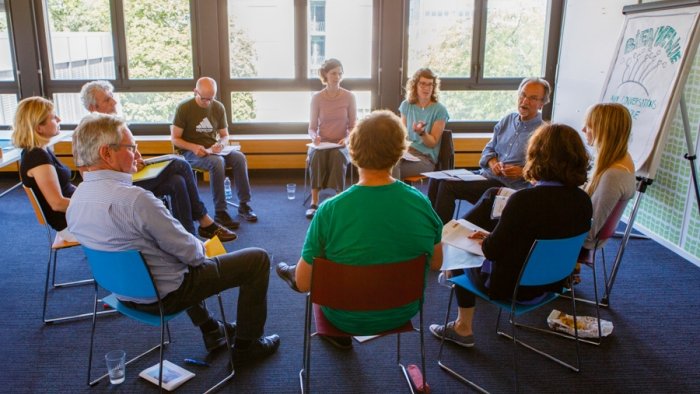 Une salle de réunion avec des personnes assises en cercle sur des chaises